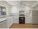 Bright kitchen with white cabinetry, modern appliances, and hardwood floors at 3987 Maceachen Blvd # 133, Sarasota, FL 34233