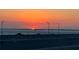 Beautiful sunset over the water with orange glow and silhouetted cars at 3987 Maceachen Blvd # 133, Sarasota, FL 34233