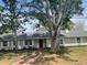 Charming single-story home boasts a red brick walkway, mature trees, and a freshly painted exterior at 1758 Winfield Cir, Clearwater, FL 33756