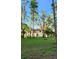 A serene backyard features a lush green lawn and mature trees, creating a tranquil outdoor retreat at 19018 Geraci Rd, Lutz, FL 33548