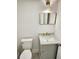 Modern half-bathroom with a stylish gold mirror, elegant vanity, and a new toilet at 19018 Geraci Rd, Lutz, FL 33548