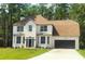 Charming two-story home with a well-manicured lawn, a black garage door, and a neutral-colored roof at 19018 Geraci Rd, Lutz, FL 33548