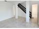 Spacious living room featuring tile flooring, neutral walls, staircase with dark wood banister at 19018 Geraci Rd, Lutz, FL 33548