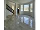Bright living room featuring sleek tile flooring, large windows and staircase at 19018 Geraci Rd, Lutz, FL 33548