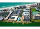 Aerial view of beachfront complex with pristine beaches, outdoor pools, tennis courts, and private boat docks at 19417 Gulf Blvd # C210, Indian Shores, FL 33785