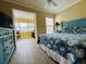 Cozy bedroom with a blue bedspread, ceiling fan, and view into the sunny sunroom at 19417 Gulf Blvd # C210, Indian Shores, FL 33785
