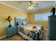Comfortable bedroom with a blue bed and a straw hat, with a bright window view at 19417 Gulf Blvd # C210, Indian Shores, FL 33785