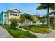 Inviting two-story building with colorful exterior, white picket fence, and lush landscaping at 19417 Gulf Blvd # C210, Indian Shores, FL 33785