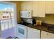 Functional kitchen with white appliances, granite countertops and access to the outside at 19417 Gulf Blvd # C210, Indian Shores, FL 33785