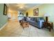 Spacious living room features tile floors, a gray sofa, and access to other parts of the house at 19417 Gulf Blvd # C210, Indian Shores, FL 33785