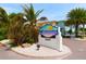 Barefoot Beach Resort sign with palm trees, landscaped island, and well-maintained grounds at 19417 Gulf Blvd # C210, Indian Shores, FL 33785