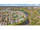 Wide aerial of a sprawling neighborhood with houses on a waterfront property, amid lush greenery and lakes at 27500 Breakers Dr, Wesley Chapel, FL 33544
