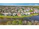 This aerial view features the home near the lake, surrounded by lush greenery and a nice community at 27500 Breakers Dr, Wesley Chapel, FL 33544