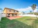 Spacious backyard with green grass, a patio with a gazebo, and a basketball hoop, enclosed by a white fence at 27500 Breakers Dr, Wesley Chapel, FL 33544