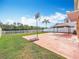 Backyard view featuring a patio with a gazebo, a basketball court, lush greenery, and a white fence at 27500 Breakers Dr, Wesley Chapel, FL 33544