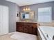 Lovely bathroom with a double sink vanity, a large mirror, and a luxurious soaking tub at 27500 Breakers Dr, Wesley Chapel, FL 33544