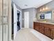 Beautiful primary bathroom with double sink granite countertop vanity, linen closet, and step-in shower at 27500 Breakers Dr, Wesley Chapel, FL 33544