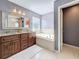 Bathroom featuring a double sink vanity with a soaking tub at 27500 Breakers Dr, Wesley Chapel, FL 33544