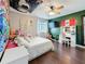 Cheerful bedroom featuring fun decor, natural light, and dark laminate flooring at 27500 Breakers Dr, Wesley Chapel, FL 33544