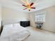 Bright bedroom with a ceiling fan, window with blinds, black dresser, and a bed with white bedding at 27500 Breakers Dr, Wesley Chapel, FL 33544
