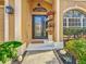 Charming front entrance with decorative glass door, flowering plants, and manicured landscaping at 27500 Breakers Dr, Wesley Chapel, FL 33544