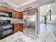 Updated kitchen with stainless steel fridge, granite countertops, and decorative wood cabinets at 27500 Breakers Dr, Wesley Chapel, FL 33544