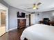 The main bedroom has hardwood floors, a ceiling fan, a tv, and ensuite bathroom access at 27500 Breakers Dr, Wesley Chapel, FL 33544