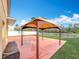 Outdoor patio featuring a gazebo on a concrete slab and surrounded by grass and white fencing at 27500 Breakers Dr, Wesley Chapel, FL 33544