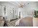 Bright bedroom with chandelier, dark wood floors, large windows, and seating area at 9050 San Martin Ne Blvd, St Petersburg, FL 33702