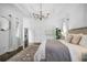 Bright bedroom with chandelier, dark wood floors, and view of walk in closet at 9050 San Martin Ne Blvd, St Petersburg, FL 33702