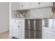 Close up of the white cabinets and stainless steel refrigerator drawers in the kitchen at 9050 San Martin Ne Blvd, St Petersburg, FL 33702