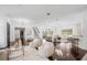 Open concept living room with hardwood floors, a chandelier, bar seating, and lots of natural light at 9050 San Martin Ne Blvd, St Petersburg, FL 33702