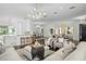 Open-concept living room with hardwood floors, a chandelier, bar seating, and lots of natural light at 9050 San Martin Ne Blvd, St Petersburg, FL 33702