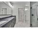 Bright bathroom featuring a double vanity, walk-in shower and doorway to closet at 10019 N Hyaleah, Tampa, FL 33617