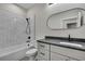 Modern bathroom features an oval mirror, gray counters, and a tub-shower combo with sleek fixtures at 10019 N Hyaleah, Tampa, FL 33617