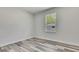 Bright bedroom with wood-look flooring and natural light from a large window at 10019 N Hyaleah, Tampa, FL 33617