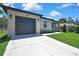 View of the property showcasing the driveway leading up to the home's garage and freshly cut lawn at 10019 N Hyaleah, Tampa, FL 33617