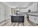 Modern kitchen featuring white cabinets, stainless steel appliances, subway tile backsplash, and a gray island at 10019 N Hyaleah, Tampa, FL 33617
