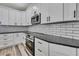 Bright kitchen showcasing the stainless steel appliances, black countertops, and subway tile backsplash at 10019 N Hyaleah, Tampa, FL 33617