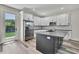 Well-lit kitchen featuring white cabinets, black hardware, stainless steel appliances, and gray stained wood floors at 10019 N Hyaleah, Tampa, FL 33617