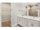Bathroom features a double vanity, white cabinets, and walk-in shower at 12193 Meditation Trl, Venice, FL 34293