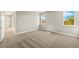 Spacious carpeted bedroom with two windows and an open doorway at 12193 Meditation Trl, Venice, FL 34293