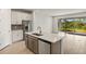 Modern kitchen with island seating, stainless appliances, stylish backsplash, and an adjoining living area at 12193 Meditation Trl, Venice, FL 34293