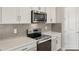 Well-equipped kitchen showcasing stainless steel appliances and white cabinets at 12193 Meditation Trl, Venice, FL 34293