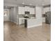 Modern kitchen with white cabinets, stainless appliances, and an island with barstool seating at 12193 Meditation Trl, Venice, FL 34293