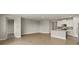 Spacious open-concept living area with tile floors and a modern kitchen with white cabinetry and stainless appliances at 12193 Meditation Trl, Venice, FL 34293