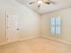 This carpeted bedroom features a ceiling fan and a window with plantation shutters at 2664 Keystone Springs Rd, Tarpon Springs, FL 34688