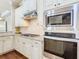 A close up of the oven, microwave, stovetop, and backsplash in a kitchen at 2664 Keystone Springs Rd, Tarpon Springs, FL 34688