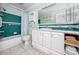 Bathroom features a shower-tub combo, blue tiles, and a white vanity with ample storage at 6025 Shore S Blvd # 311, Gulfport, FL 33707