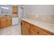 Efficient kitchen space with tile countertops and ample storage in wooden cabinets at 6025 Shore S Blvd # 311, Gulfport, FL 33707